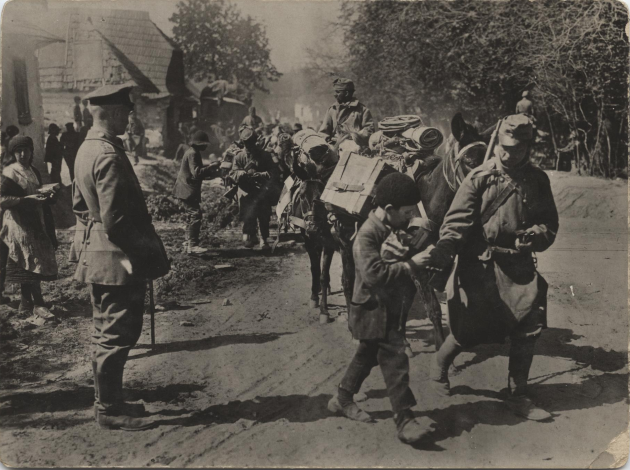 Black and white photo of Austro-Hungarian soldiers marching through a street.